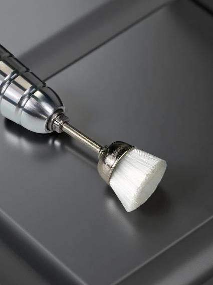 Close-up of a small soft nylon brushes with white bristles on metallic bases on a reflective gray surface. This Brush E-File Bit, designed to replace traditional nail brushes for a faster, more efficient cleaning process. 