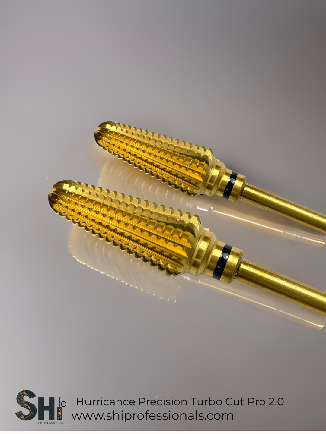 Two gold tungsten carbide nail drill bit with SHI branding on a gray background