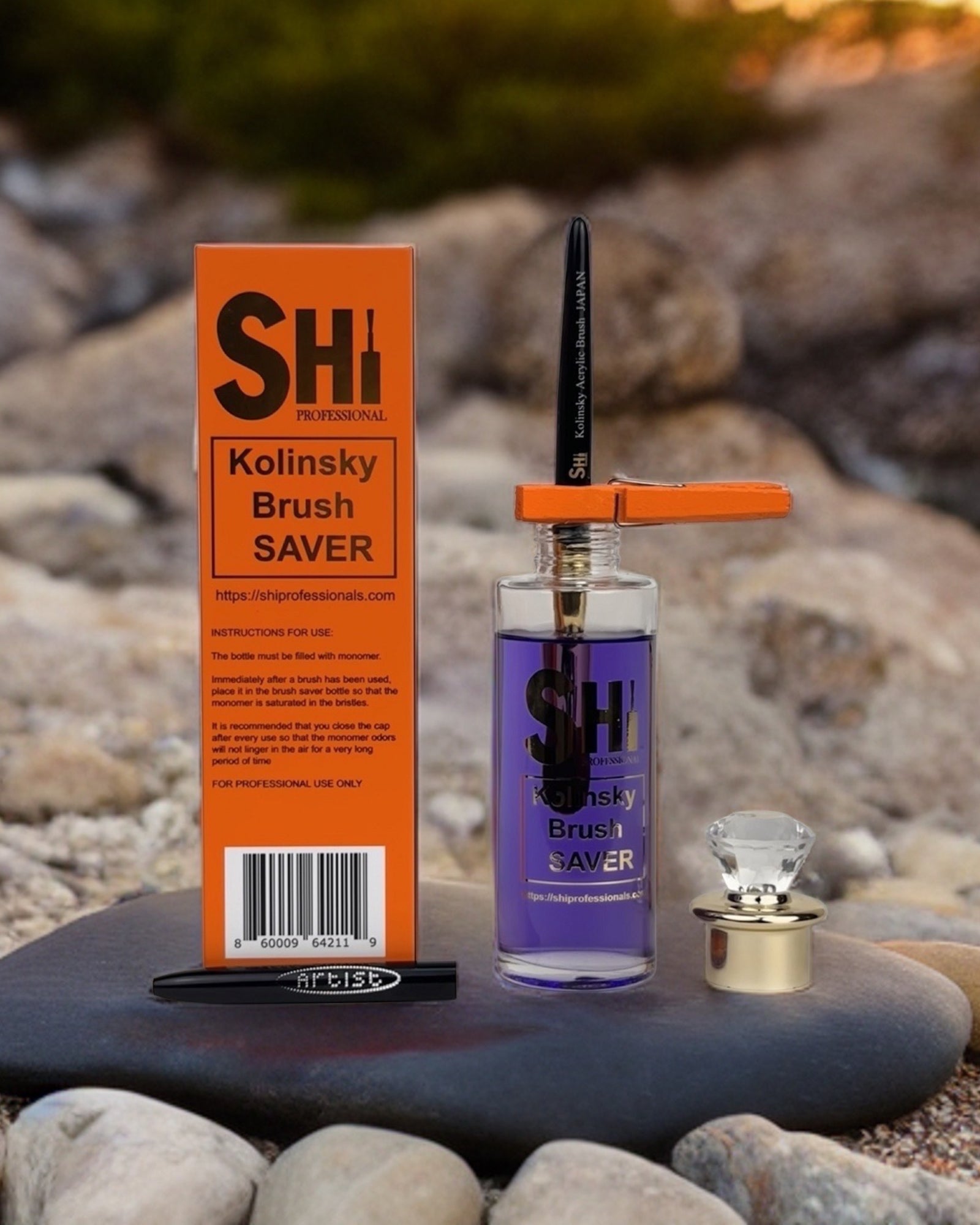 The image shows a Kolinsky acrylic brush saver kit which includes a brush, a bottle with liquid, and a clip, displayed on a stone surface.