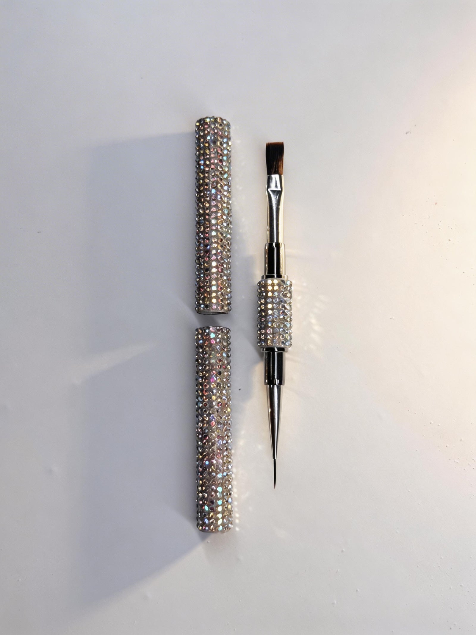 Decorative dual-ended flat brush with crystal embellishments on a white background