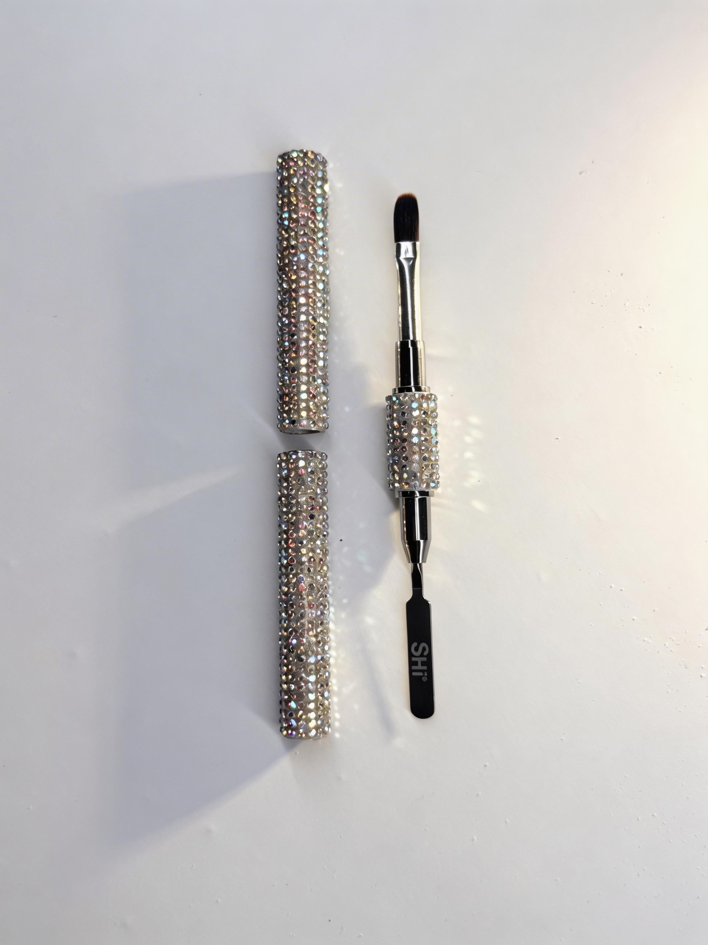 Polygel brush with rhinestone handle on a white background