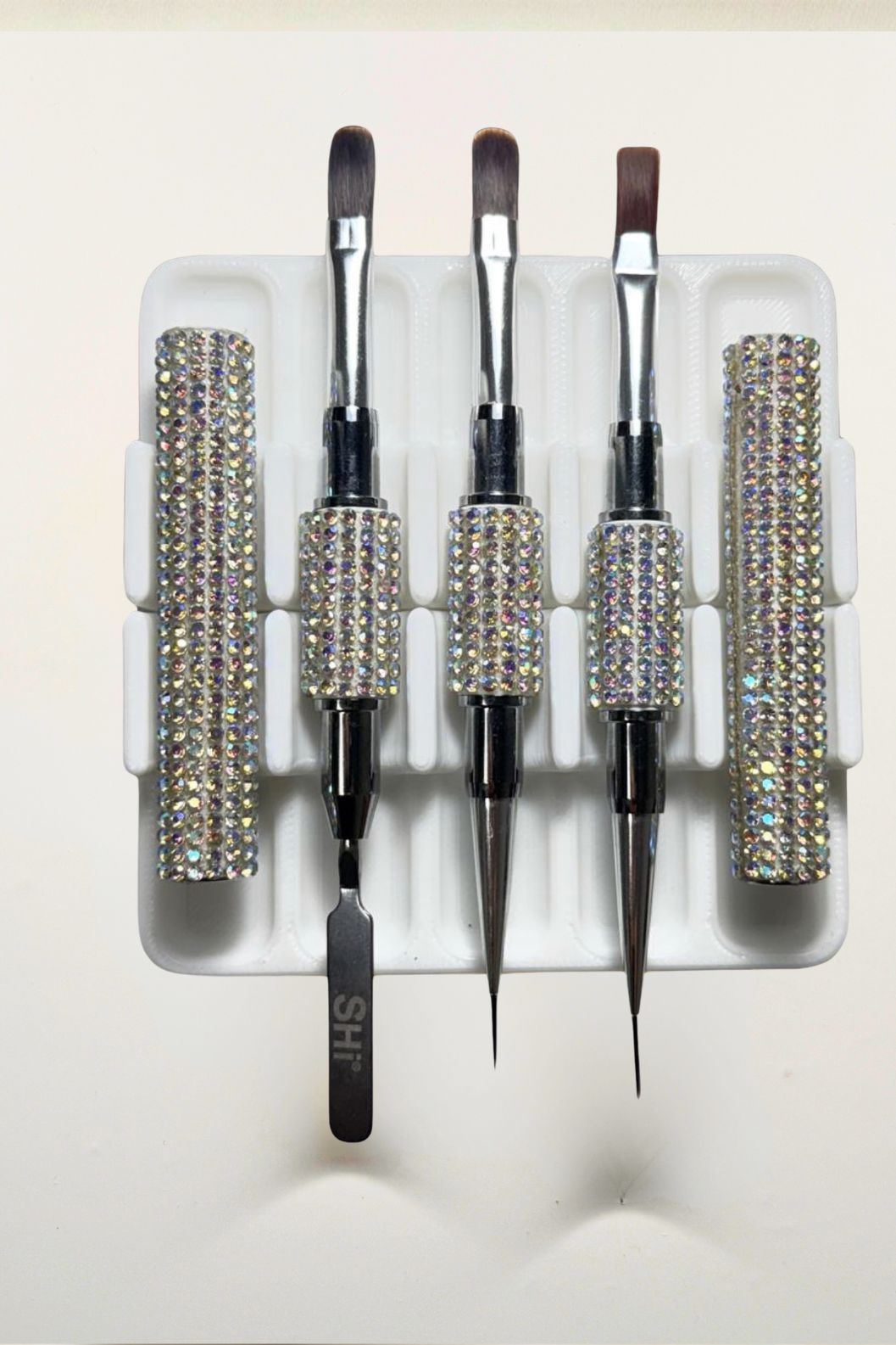 Set of builder gel brushes in a box with nail care products on a light background