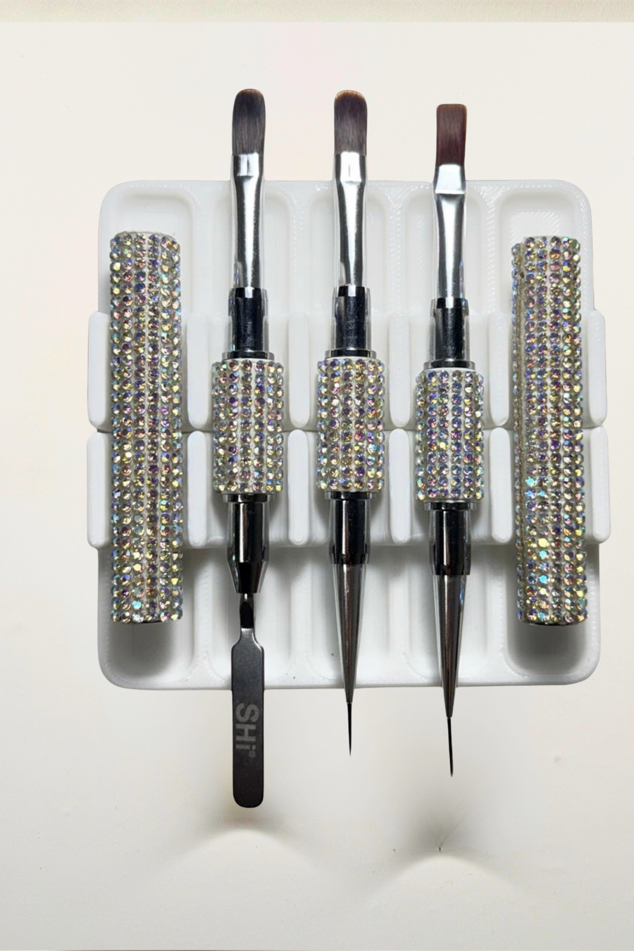Set of builder gel brushes in a box with nail care products on a light background