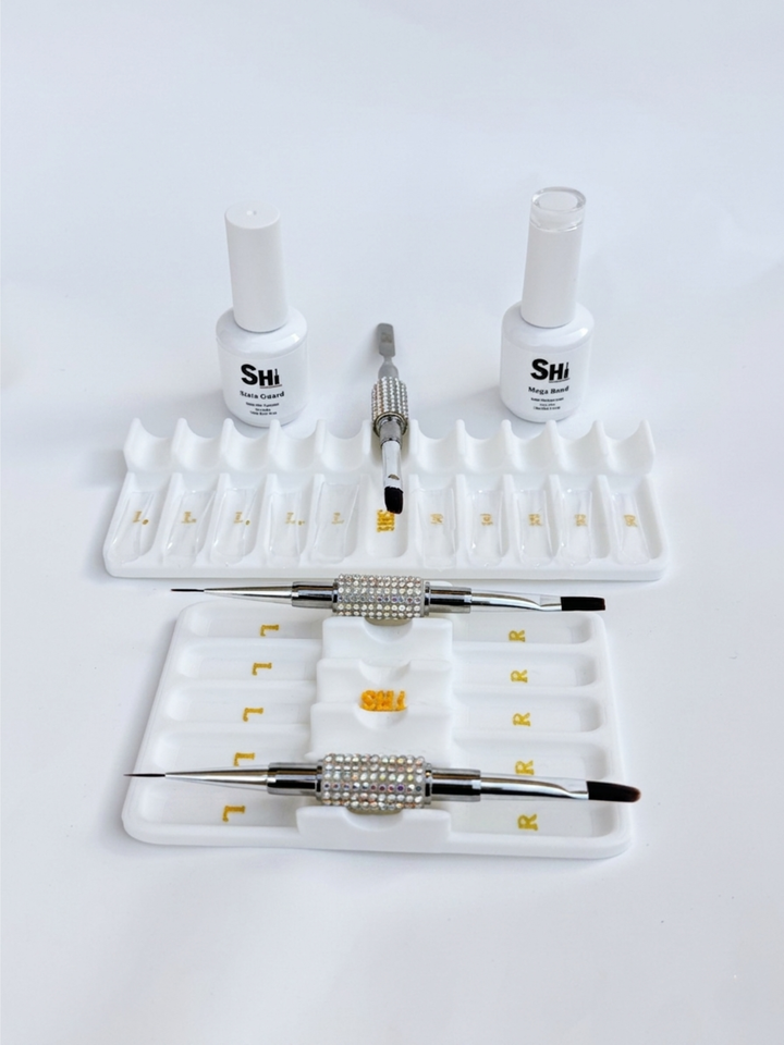 Nail art tool set with bottles, brushes, and a stand on a white background