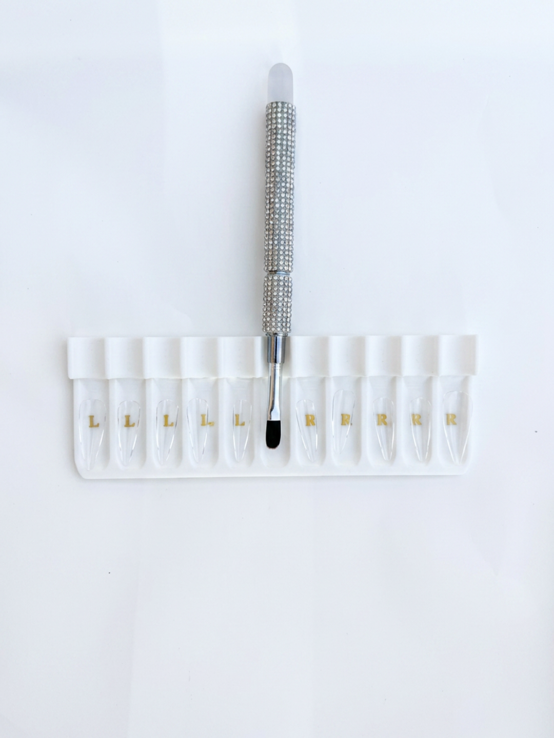 Set of small vials with a bling builder gel brush on a white background