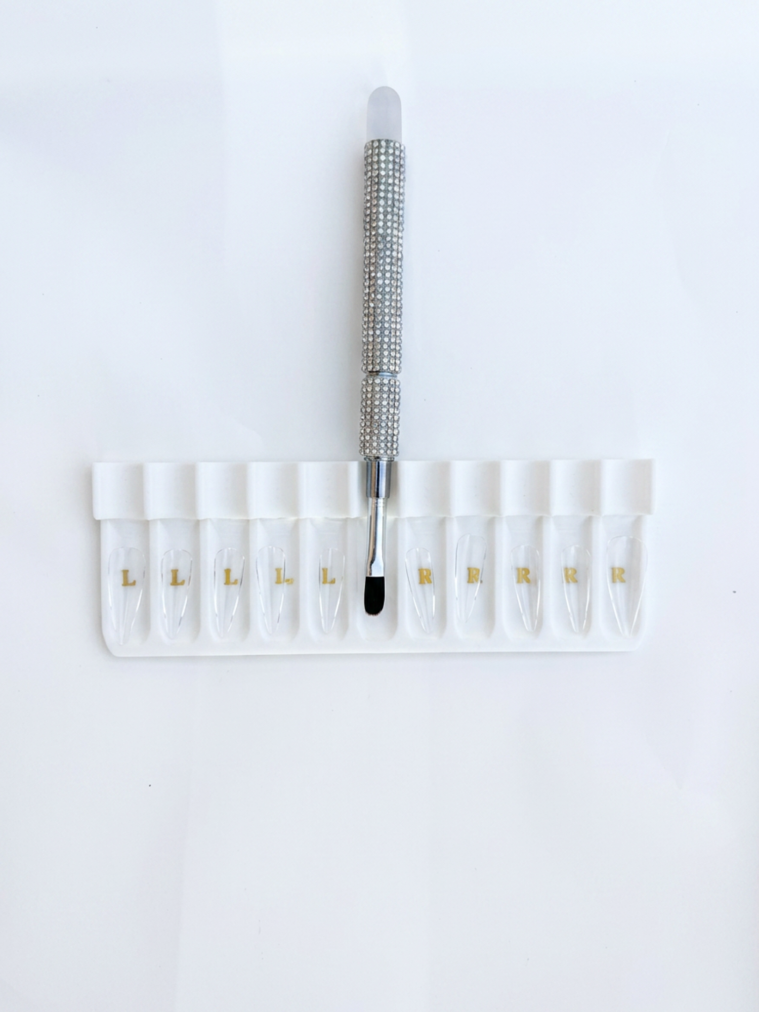 Set of small vials with a bling builder gel brush on a white background