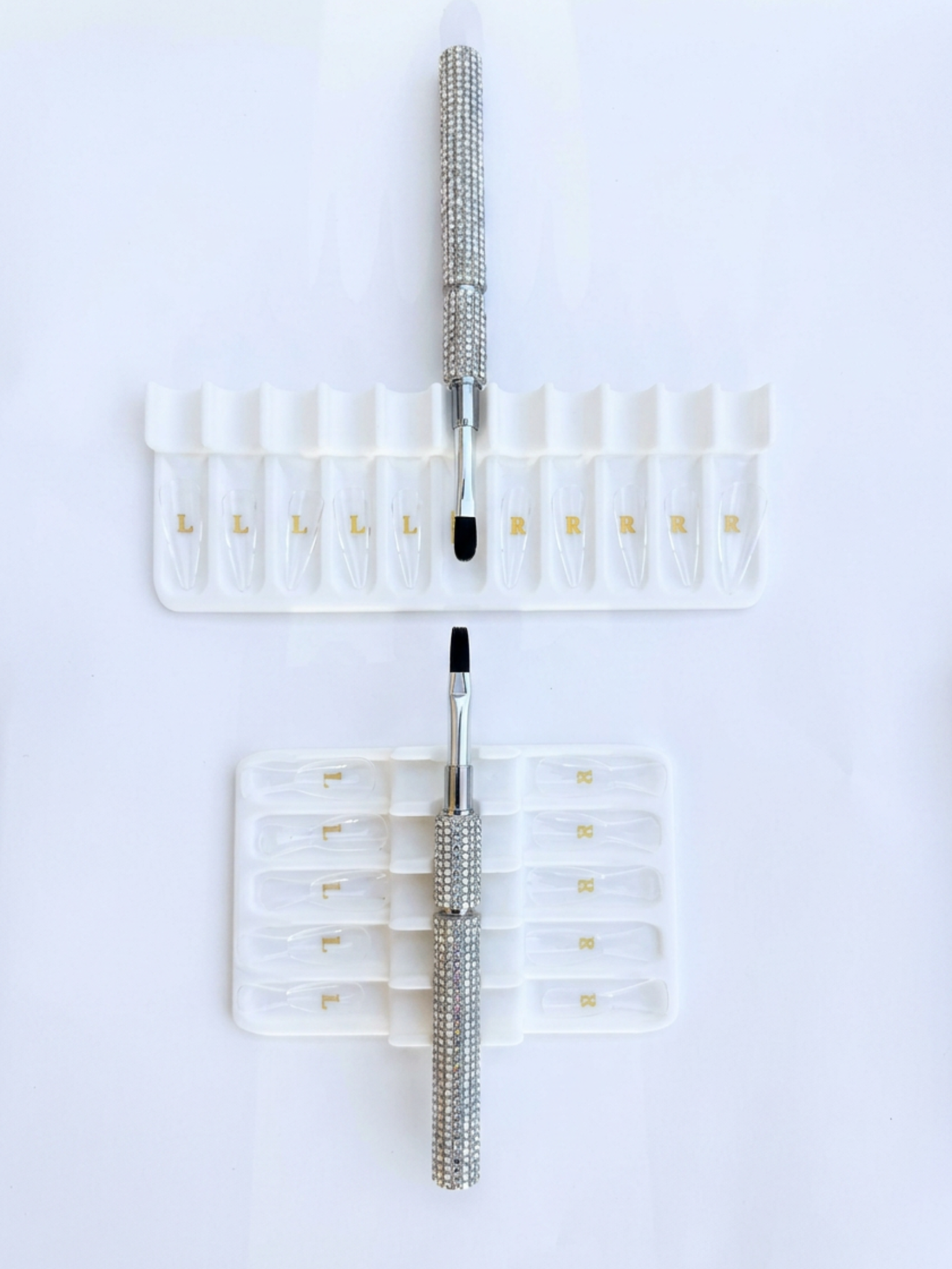 Set of builder gel brushes with white tray holders on a white background