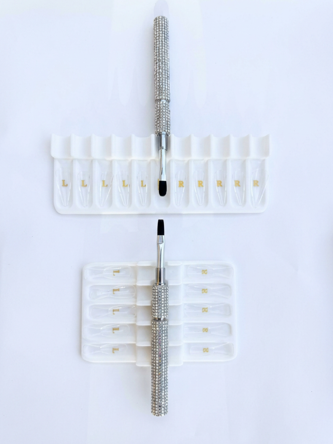 Set of builder gel brushes with white tray holders on a white background