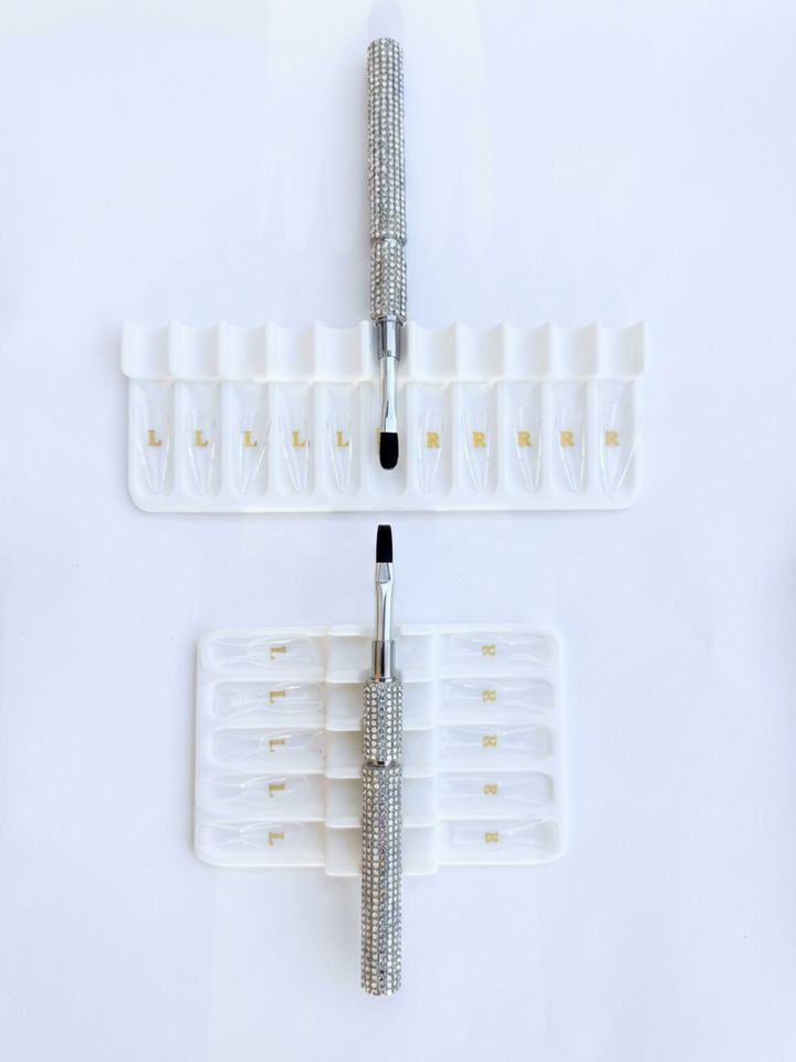 Set of builder gel brushes with white tray holders on a white background