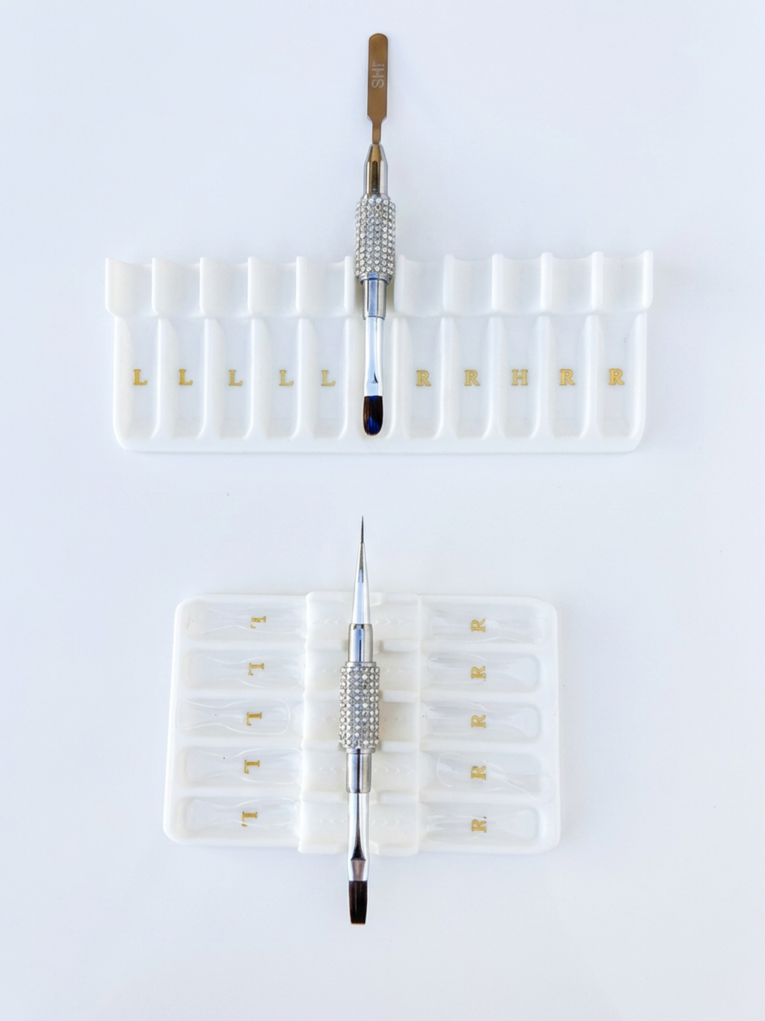 Set of builder gel brushes in white tray holders on a white background