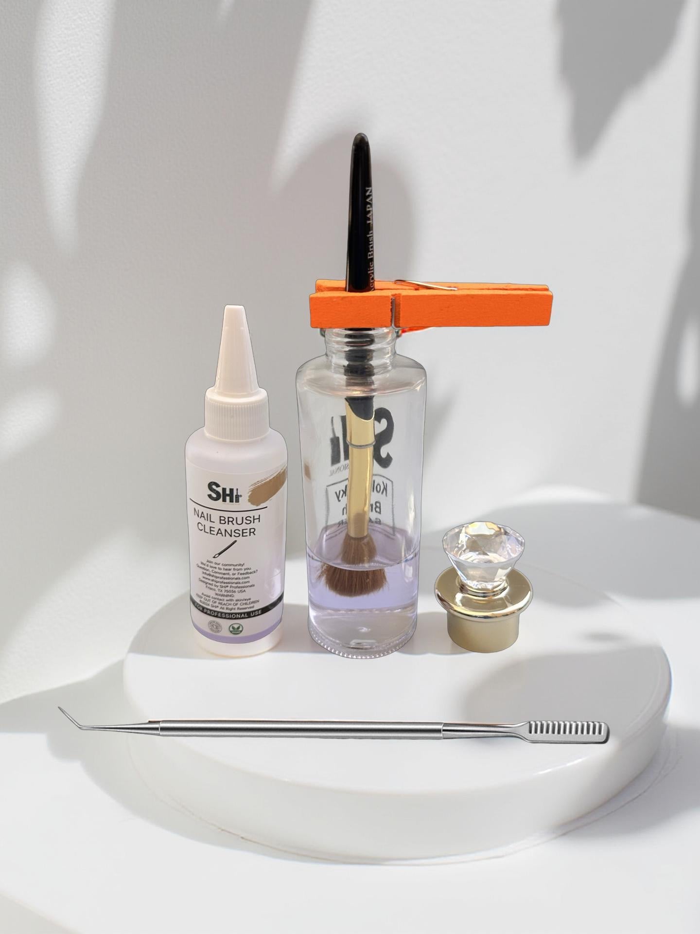 The image shows a Kolinsky acrylic brush saver kit which includes a brush, a bottle with liquid, a clip, and a brush comb displayed on a white surface with a neutral background